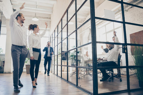 Full length photo of positive freelancers man woman go walk, training hold hand greet colleagues sit table in boardroom workplace workstation