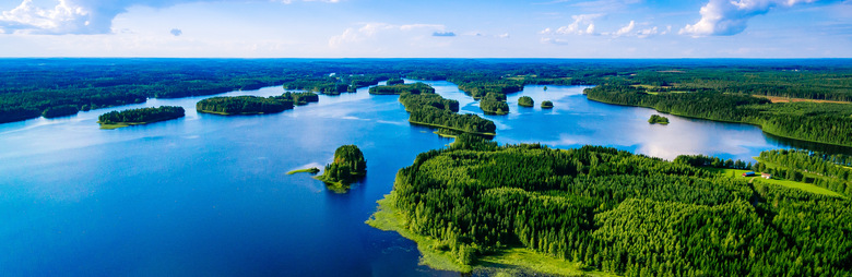 Aerial top view of blue lakes with islands and green forests in Finland. Beautiful summer landscape.