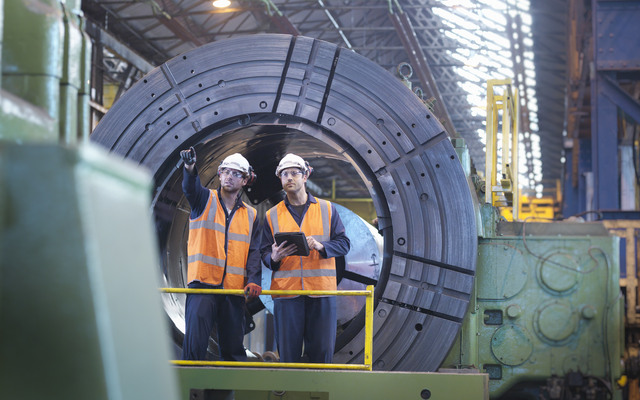 Engineers working together in engineering factory