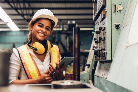 Industry maintenance engineer woman dark skin wearing uniform and safety helmet under inspection and checking production process on factory station by tablet. Industry, Engineer, construction concept.