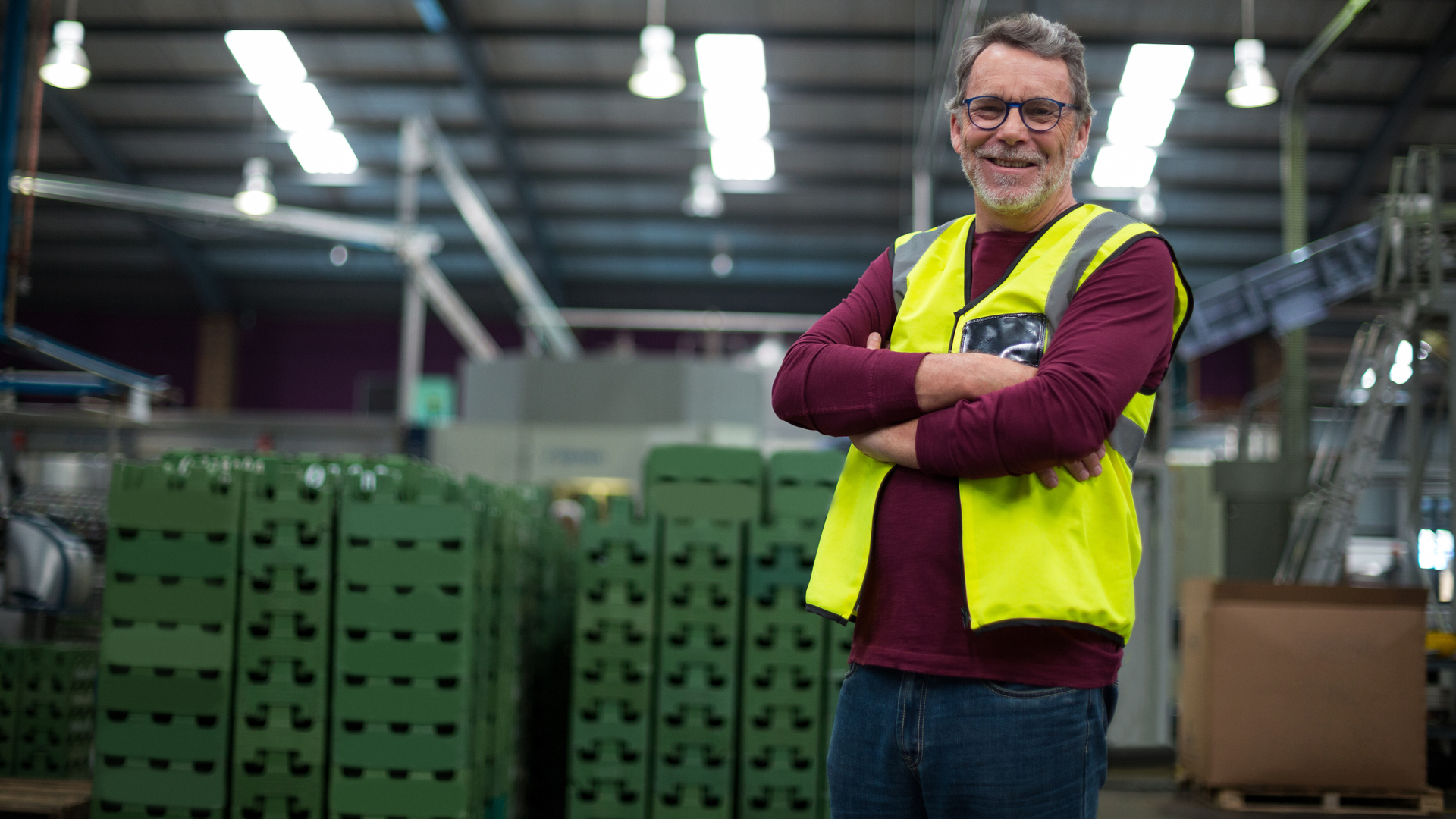 Portrait of male factory worker standing with arms crossed in drinks production factory